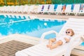 Cute baby relaxing at sunbed near pool at hawaii, hotel