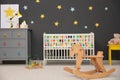 Cute baby room interior with crib and rocking horse Royalty Free Stock Photo