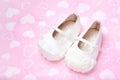 Cute baby shoes for kids on heart pink towel.
