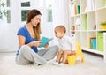 Cute baby sitting on bedpan and listening kid story Royalty Free Stock Photo