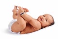 Cute baby sleeping on bed holding his feet and laughing, Pune, Maharashtra