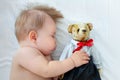 Cute baby sleeping in crib with teddy bear, little boy cozy daytime nap Royalty Free Stock Photo