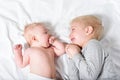 Cute baby and smiling older brother are lying on the bed. Play and interact. Top view Royalty Free Stock Photo