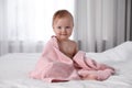 Cute little baby with soft pink towel on bed after bath Royalty Free Stock Photo