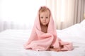 Cute little baby with soft pink towel on bed after bath Royalty Free Stock Photo