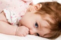 Cute baby sucks his thumb lying in bed Royalty Free Stock Photo