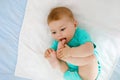 Cute baby taking feet in mouth. Adorable little baby girl sucking foot. Royalty Free Stock Photo