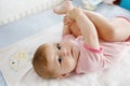 Cute baby taking feet in mouth. Adorable little baby girl sucking foot. Royalty Free Stock Photo