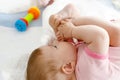 Cute baby taking feet in mouth. Adorable little baby girl sucking foot. Royalty Free Stock Photo