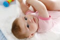 Cute baby taking feet in mouth. Adorable little baby girl sucking foot. Royalty Free Stock Photo