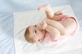 Cute baby taking feet in mouth. Adorable little baby girl sucking foot. Royalty Free Stock Photo