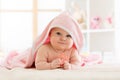 Cute baby with teether under a hooded towel after bath