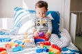 Cute baby toddler playing building with learning toy stacking blocks at home. Early age education. Kids hand brain and fine motor Royalty Free Stock Photo