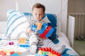 Cute baby toddler playing building with learning toy stacking blocks at home. Early age education. Kids hand brain and fine motor Royalty Free Stock Photo