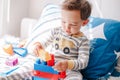 Cute baby toddler playing building with learning toy stacking blocks at home. Early age education. Kids hand brain and fine motor Royalty Free Stock Photo