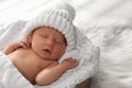 Cute newborn baby in warm hat sleeping on knitted blanket Royalty Free Stock Photo