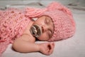 Cute baby in warm hat sleeping on light bedsheet