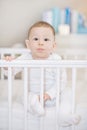Cute baby in the white crib - portait of a lovely child