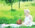 Cute baby in a wreath on a picnic on a summer day.