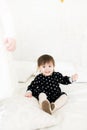 Cute baby 2 year old sitting on a bed with a balloon. Birthday party. Celebration