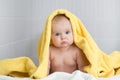 Cute baby in yellow bathing towel in bathroom