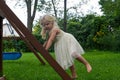 Cute barefoot girl climbing swingset ladder