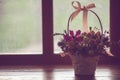 Cute basket with roses, flower arrangement on the windowsill, side view