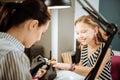 Cute beaming teenage girl feeling excited coming to manicure saloon