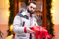 Cute bearded man holds a box with a Christmas gift in his hands Royalty Free Stock Photo