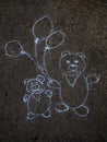 Cute bears with balloons sketching with blue chalk on the asphalt