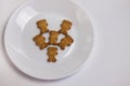 Cute bears cookies on the ceramic round plate isolated on white background. View from above, flat lay.