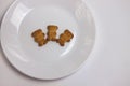 Cute bears cookies on the ceramic round plate isolated on white background. View from above, flat lay.