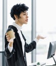 Cute and beautiful businesswoman in casual suit dress holding coffee cup and pose like say somthing Royalty Free Stock Photo