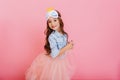 Cute beautiful carnival kid having fun isolated on pink background. Pretty little girl with long brunette hair, tulle Royalty Free Stock Photo