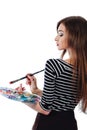 Cute beautiful girl artist holding a palette and brush in the process draws inspiration. White background, isolated. Royalty Free Stock Photo