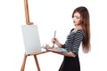 Cute beautiful girl artist painting a picture on canvas easel. Space for text. Studio white background, isolated. Royalty Free Stock Photo