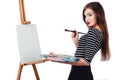 Cute beautiful girl artist painting a picture on canvas easel. Space for text. Studio white background, isolated. Royalty Free Stock Photo