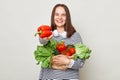 Cute beautiful healthy woman embraces fresh vegetables posing  over white background offering red pepper enjoying orgnic Royalty Free Stock Photo