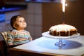 Cute beautiful little baby girl celebrating first birthday. Child blowing one candle on homemade baked cake, indoor Royalty Free Stock Photo