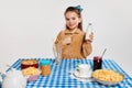 Cute beautiful little girl having yummy breakfast with cereal, posing against grey studio background. Concept of Royalty Free Stock Photo