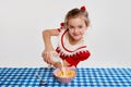 Cute beautiful little girl having yummy healthy breakfast with cereal, posing against grey studio background. Concept of Royalty Free Stock Photo