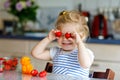 Cute beautiful little toddler girl eating fresh strawberries. Adorable baby child tasting berry and feeding toy bear Royalty Free Stock Photo