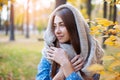 Cute beautiful smile woman walking in yellow autumn park. Girl in knitten scarf near tree and she is happy Royalty Free Stock Photo