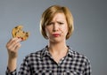 Cute beautiful woman with chocolate stain in mouth eating big delicious cookie Royalty Free Stock Photo