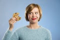 Cute beautiful woman with chocolate stain in mouth eating big delicious cookie Royalty Free Stock Photo