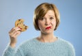 Cute beautiful woman with chocolate stain in mouth eating big delicious cookie