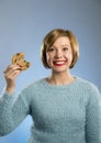 Cute beautiful woman with chocolate stain in mouth eating big delicious cookie Royalty Free Stock Photo