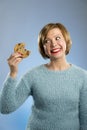 Cute beautiful woman with chocolate stain in mouth eating big delicious cookie Royalty Free Stock Photo