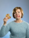 Cute beautiful woman with chocolate stain in mouth eating big delicious cookie Royalty Free Stock Photo