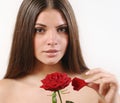 Cute beautiful woman tears off petals of red rose and looking at Royalty Free Stock Photo